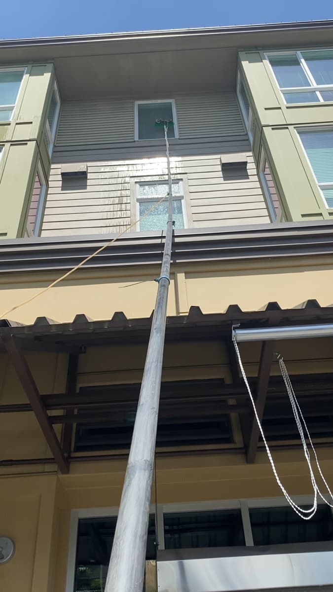 Cleaning upper-floor apartment windows from the ground