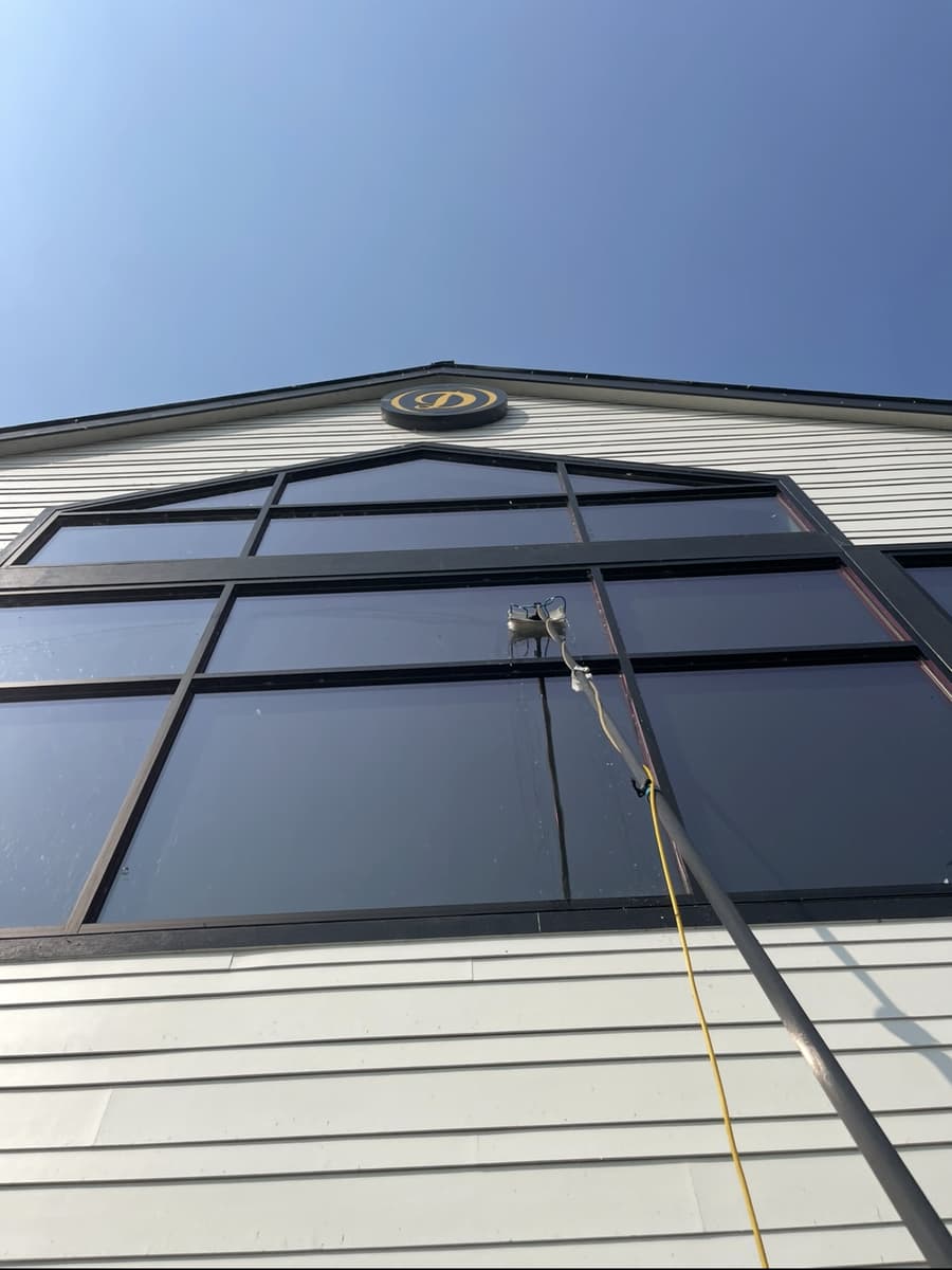 Washing tall commercial windows with a water-fed pole